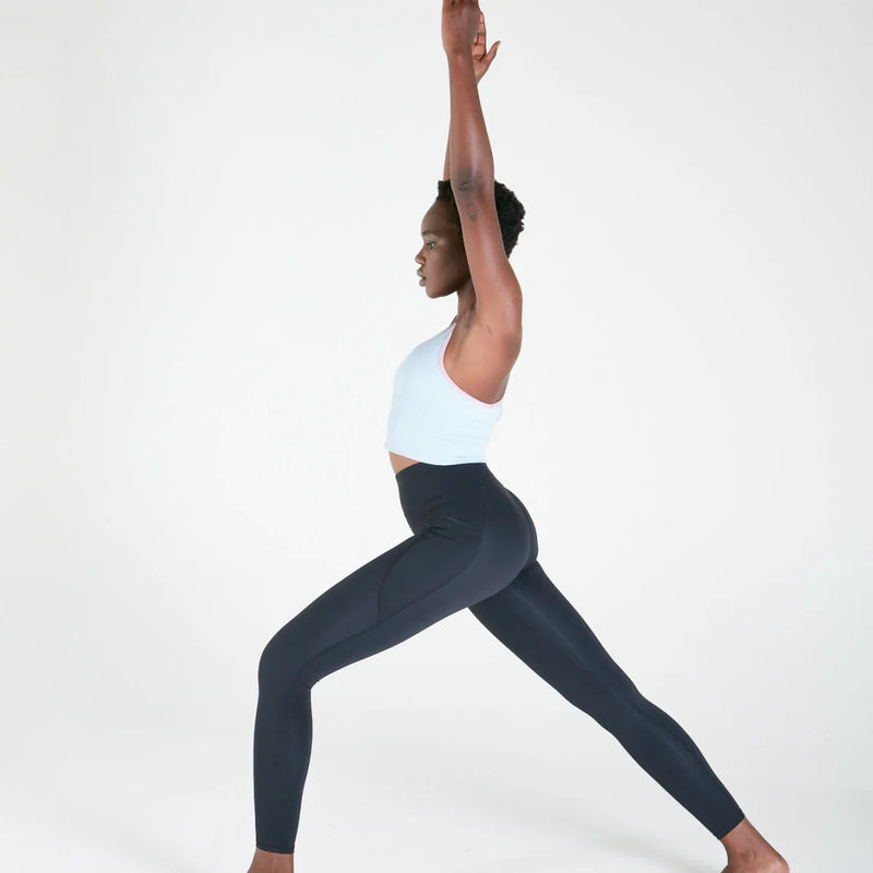 Woman in yoga pose stretching upward, wearing Vibe Leggings with regular fit waistband